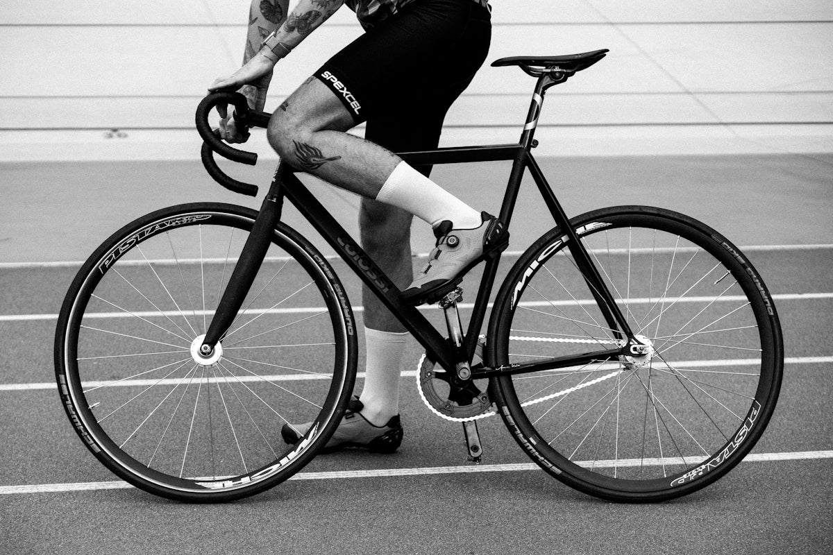 Cyclist riding on a track with a fixed gear bike.